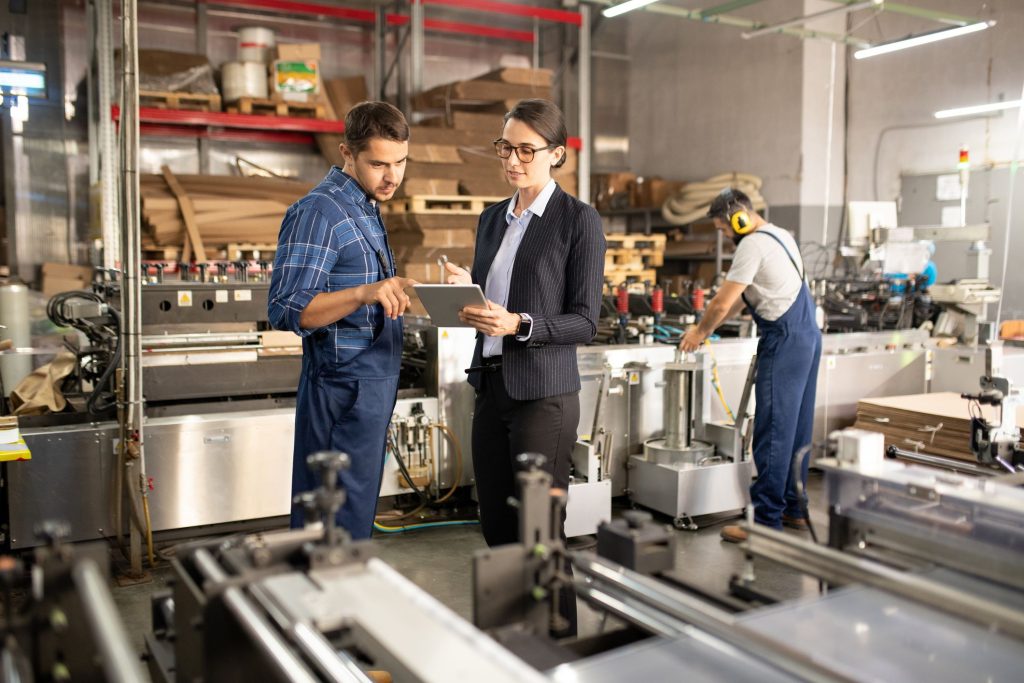Um homem e uma mulher no ambiente de trabalho conversando sobre a NR12