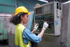Mulher negra em seu local de trabalho realizando laudo da NR 12