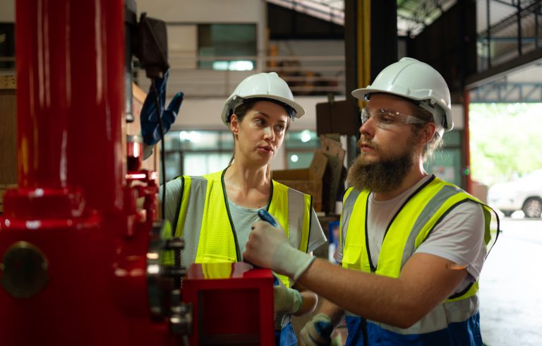 Duas pessoas em seu local de trabalho realizando manutenção preditiva